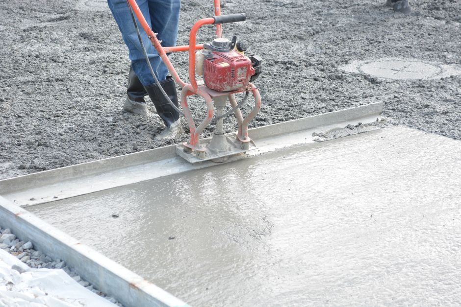 Concrete finisher working a fresh slab with a trowel